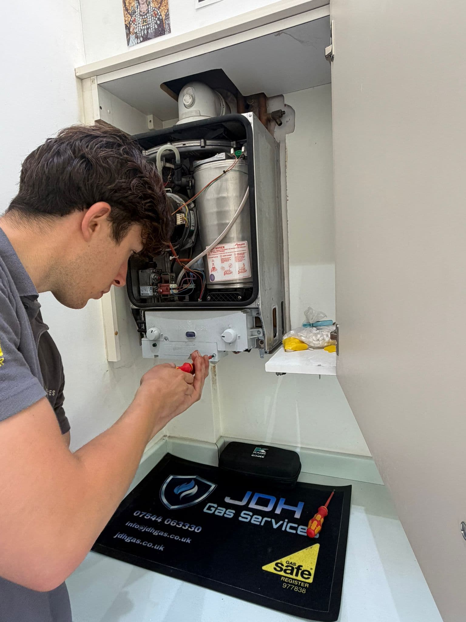 Jamie Hannah, Gas Safe registered engineer covering Ditchling, working on an open boiler during a service