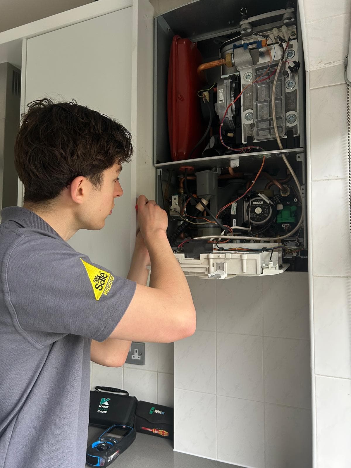Jamie Hannah, Gas Safe registered engineer, servicing an open Bosch boiler in Burgess Hill