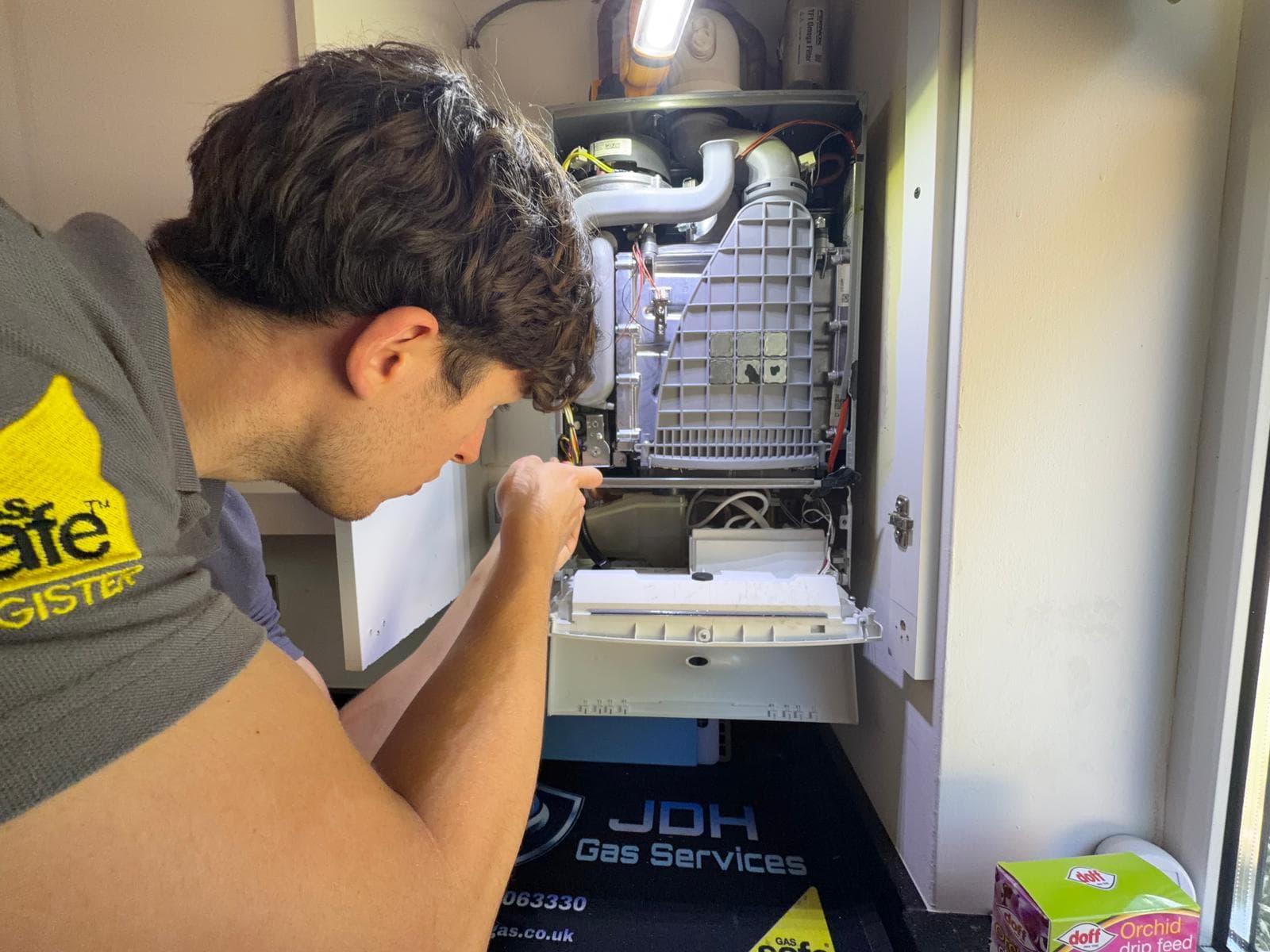 Jamie Hannah, Gas Safe registered engineer, inspecting an open boiler during an annual service