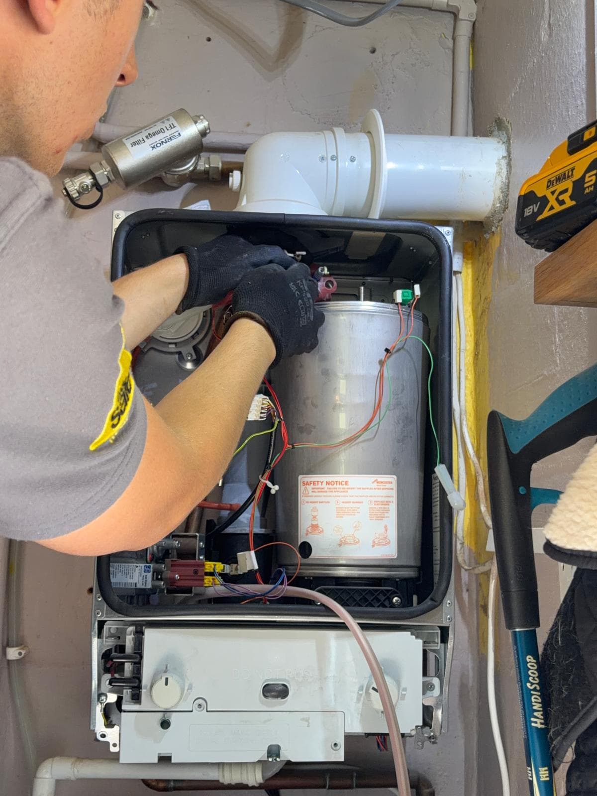 Jamie Hannah, Gas Safe registered engineer, cleaning the internals of a stripped-down boiler